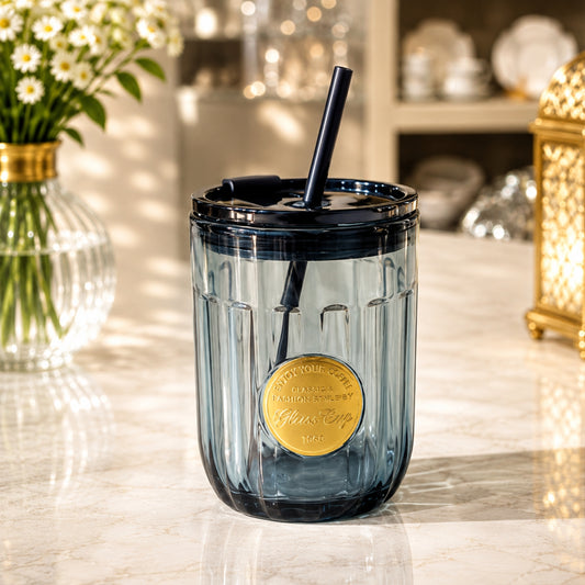 Dark blue cola glass cup with vertical fluted design, gold-tone medallion, lid and straw